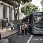 Ônibus urbano transporta passageiros nas proximidades de uma seção eleitoral durante as eleições.