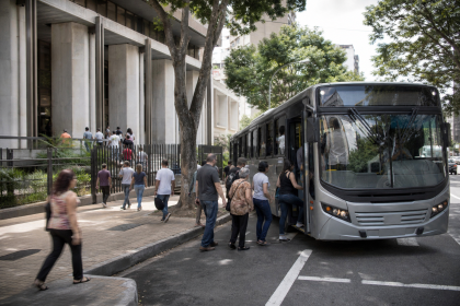 Ônibus urbano transporta passageiros nas proximidades de uma seção eleitoral durante as eleições.
