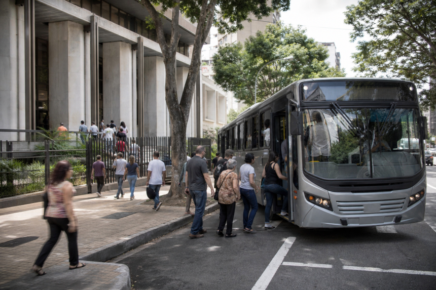Ônibus urbano transporta passageiros nas proximidades de uma seção eleitoral durante as eleições.