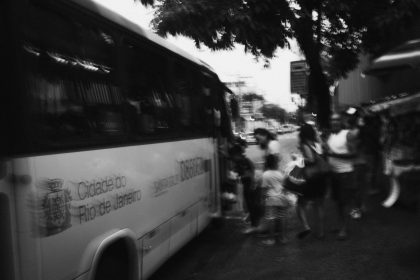 Passageiros embarcam em um ônibus no Rio de Janeiro em uma imagem em preto e branco.