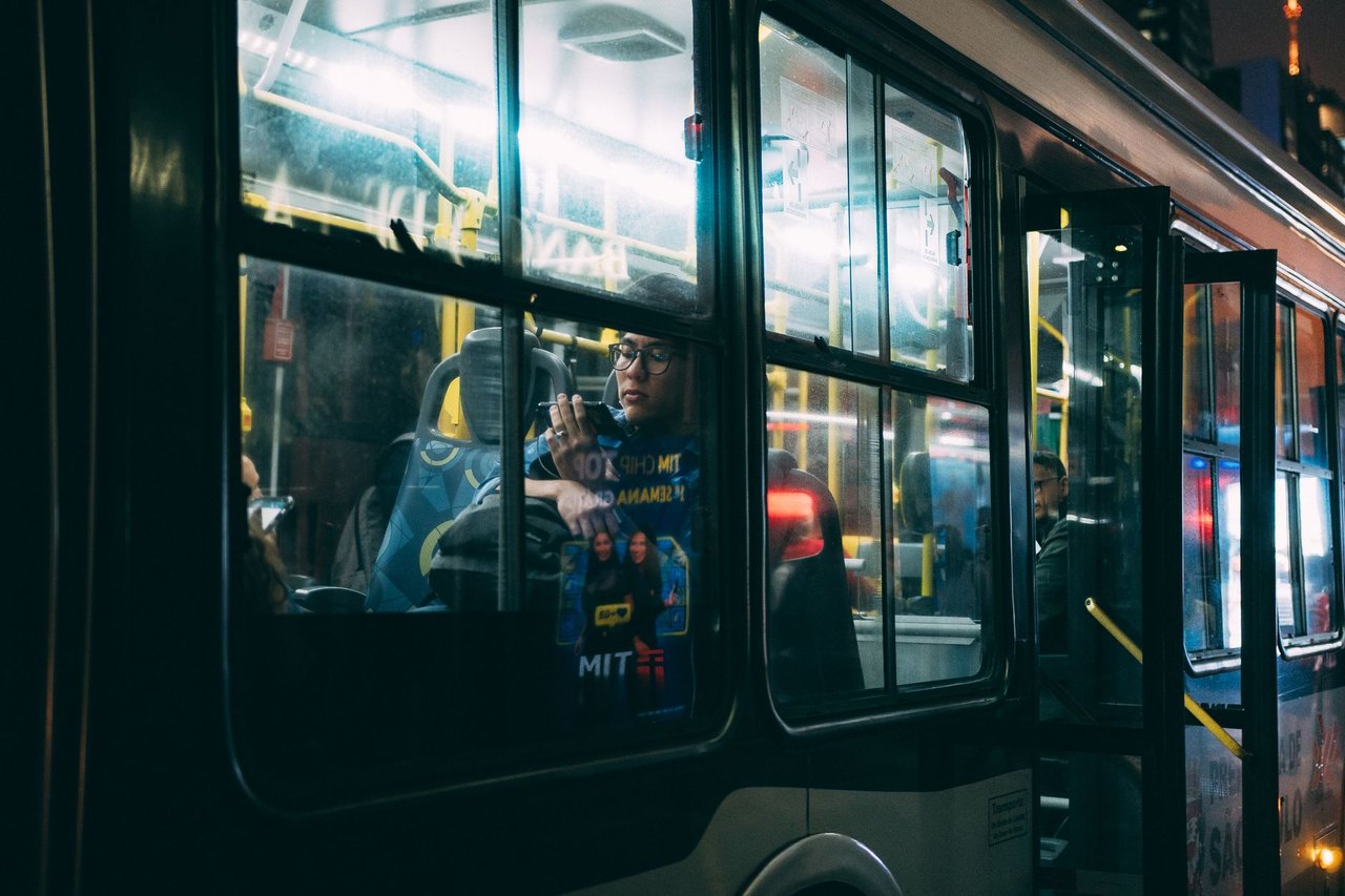 Passageiros viajam em um ônibus urbano durante a noite em São Paulo.