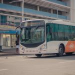 Ônibus urbano parado no ponto enquanto passageiros embarcam.