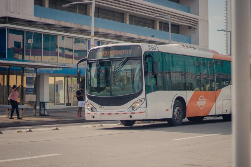 Ônibus urbano parado no ponto enquanto passageiros embarcam.