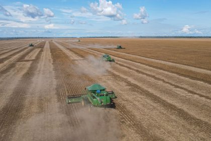 Colheitadeiras trabalham em uma extensa plantação de soja no Brasil.